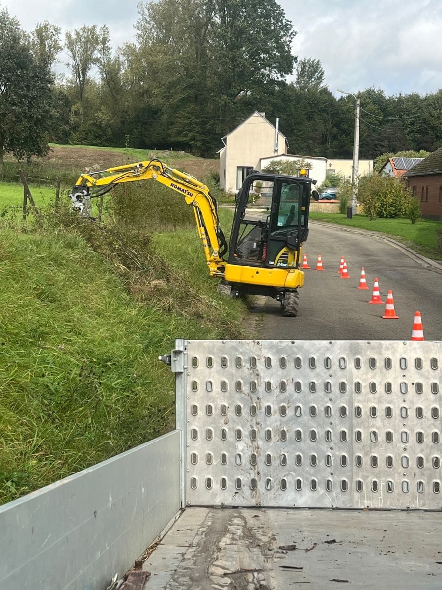 Graafmachine van JDC BV ruimt een gracht langs de openbare weg.
